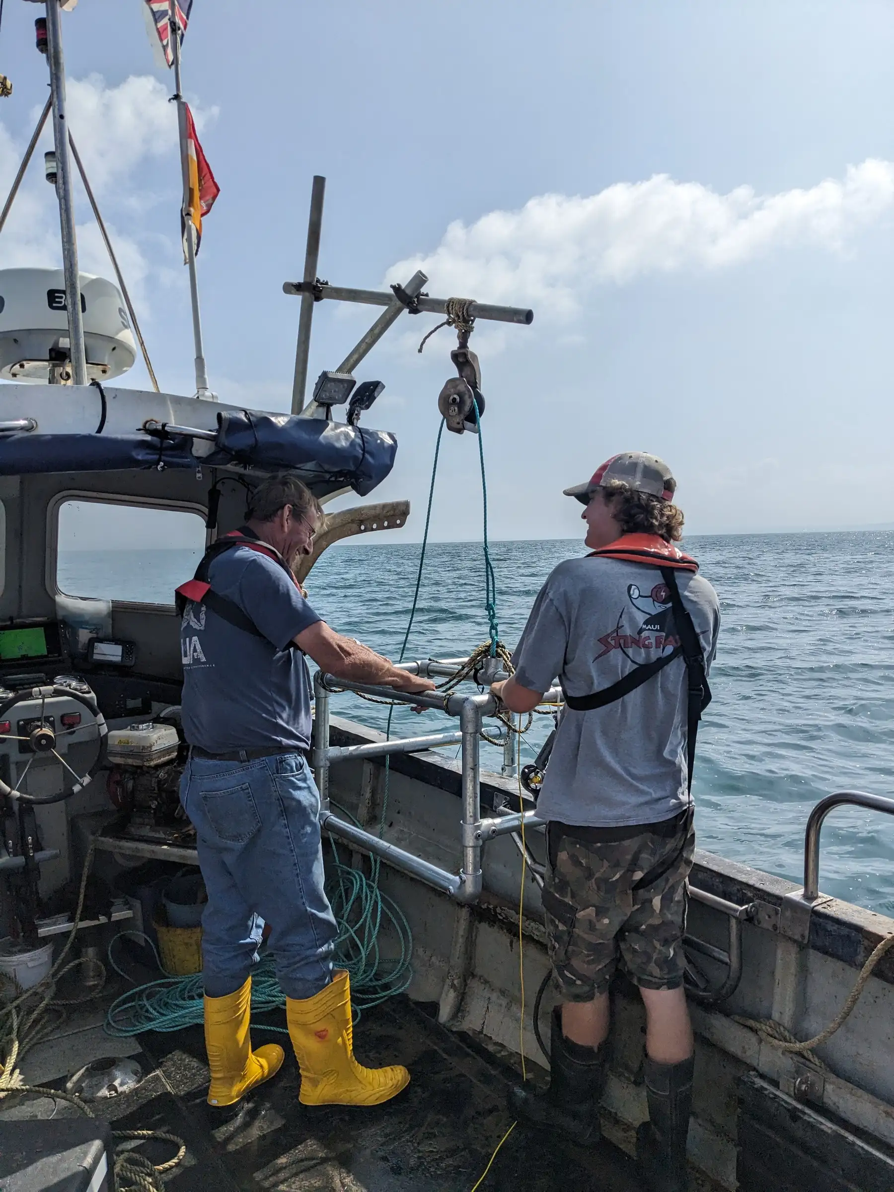 Person in waders on a boat preparing monitoring equipment