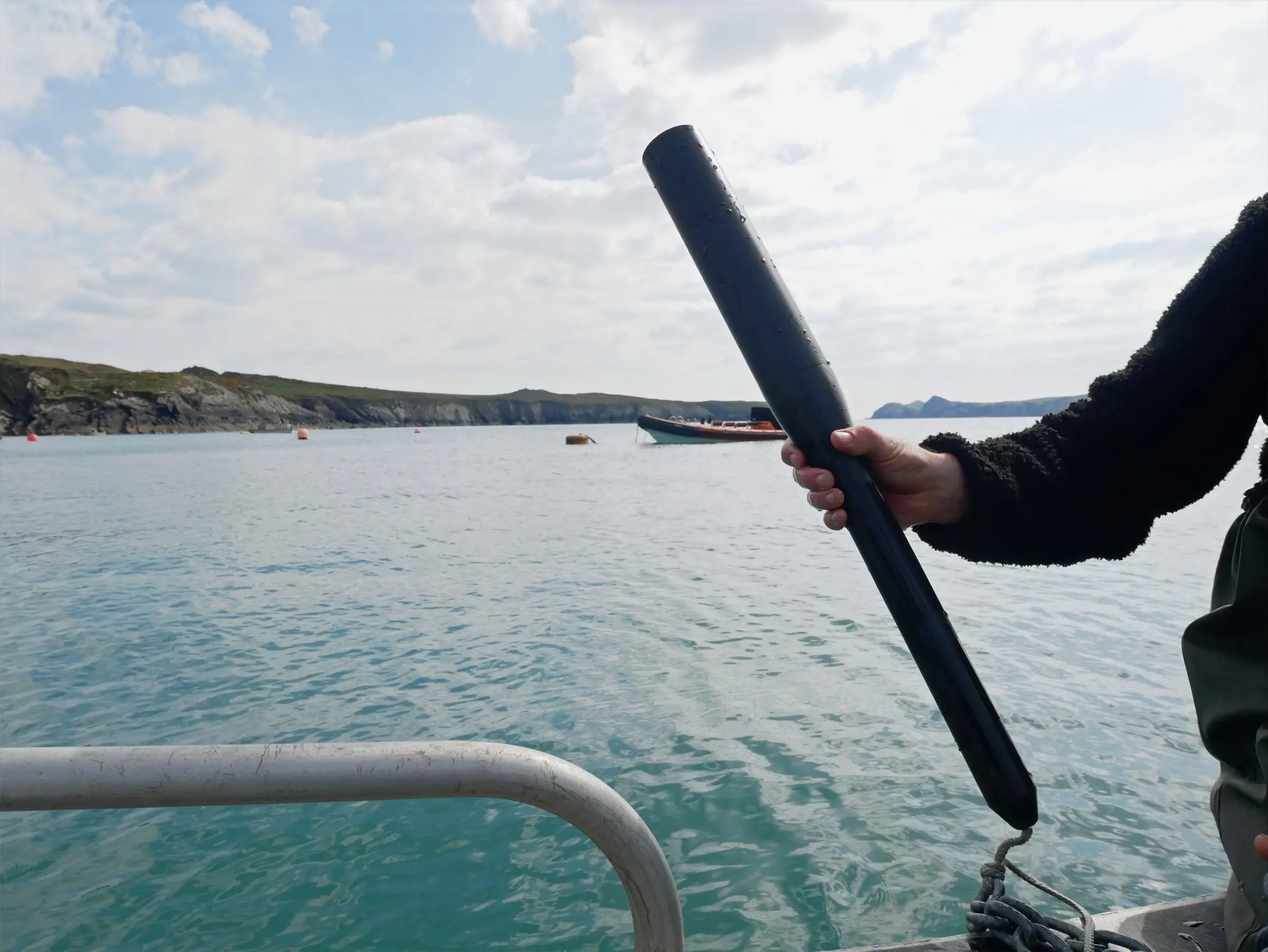 A GrowProbe 4 held over the side of a boat on a calm bay