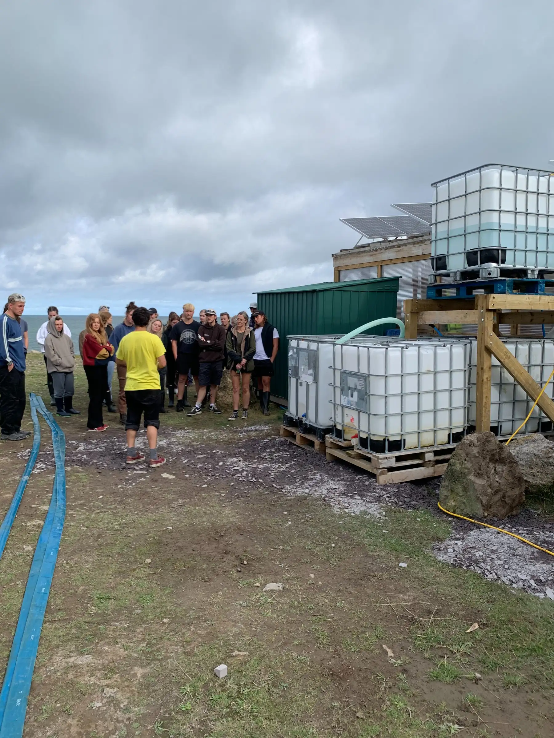 Workshop participants gathered beside seaweed cultivation tanks