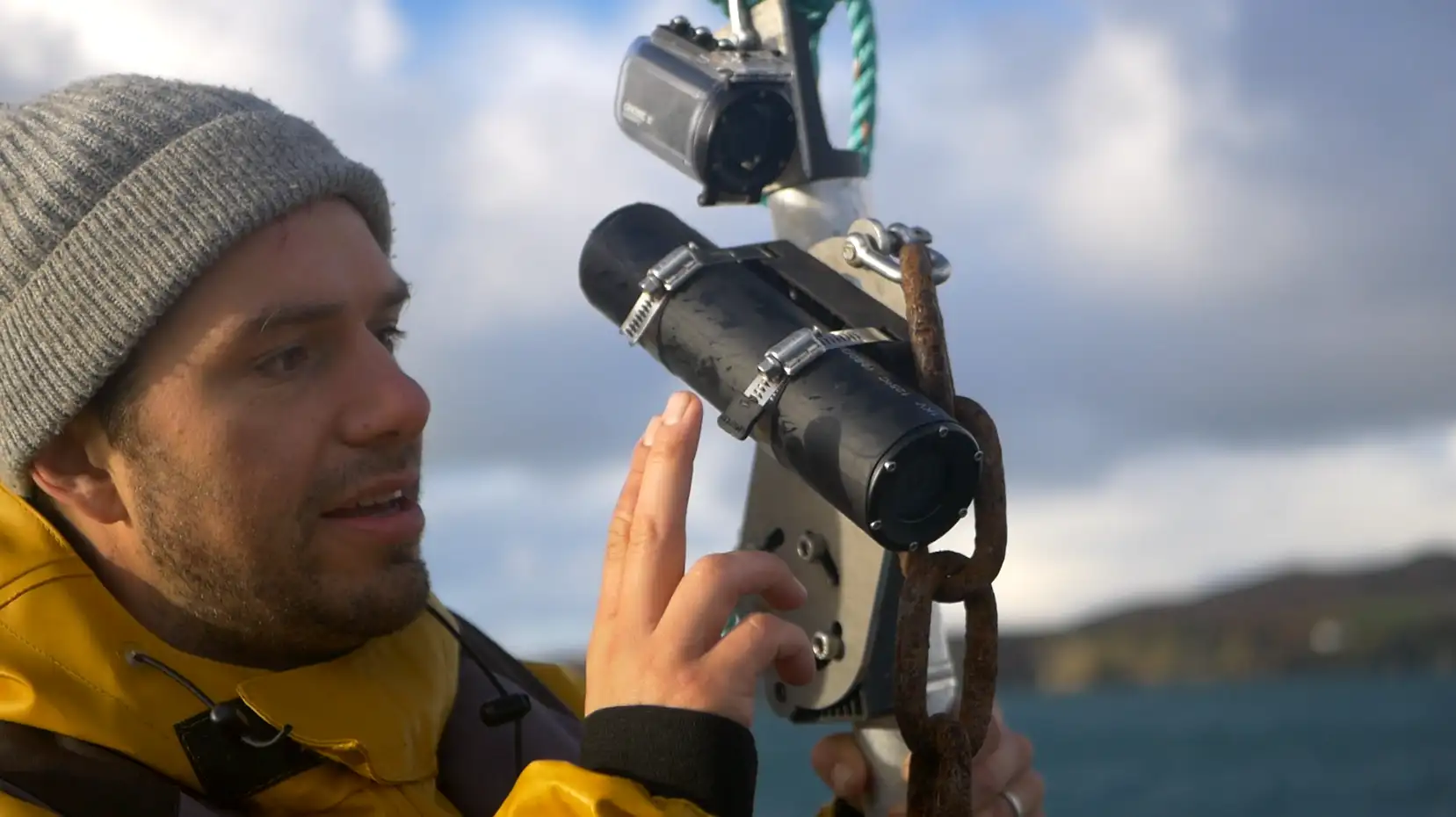 Person on a boat inspecting an underwater monitoring camera
